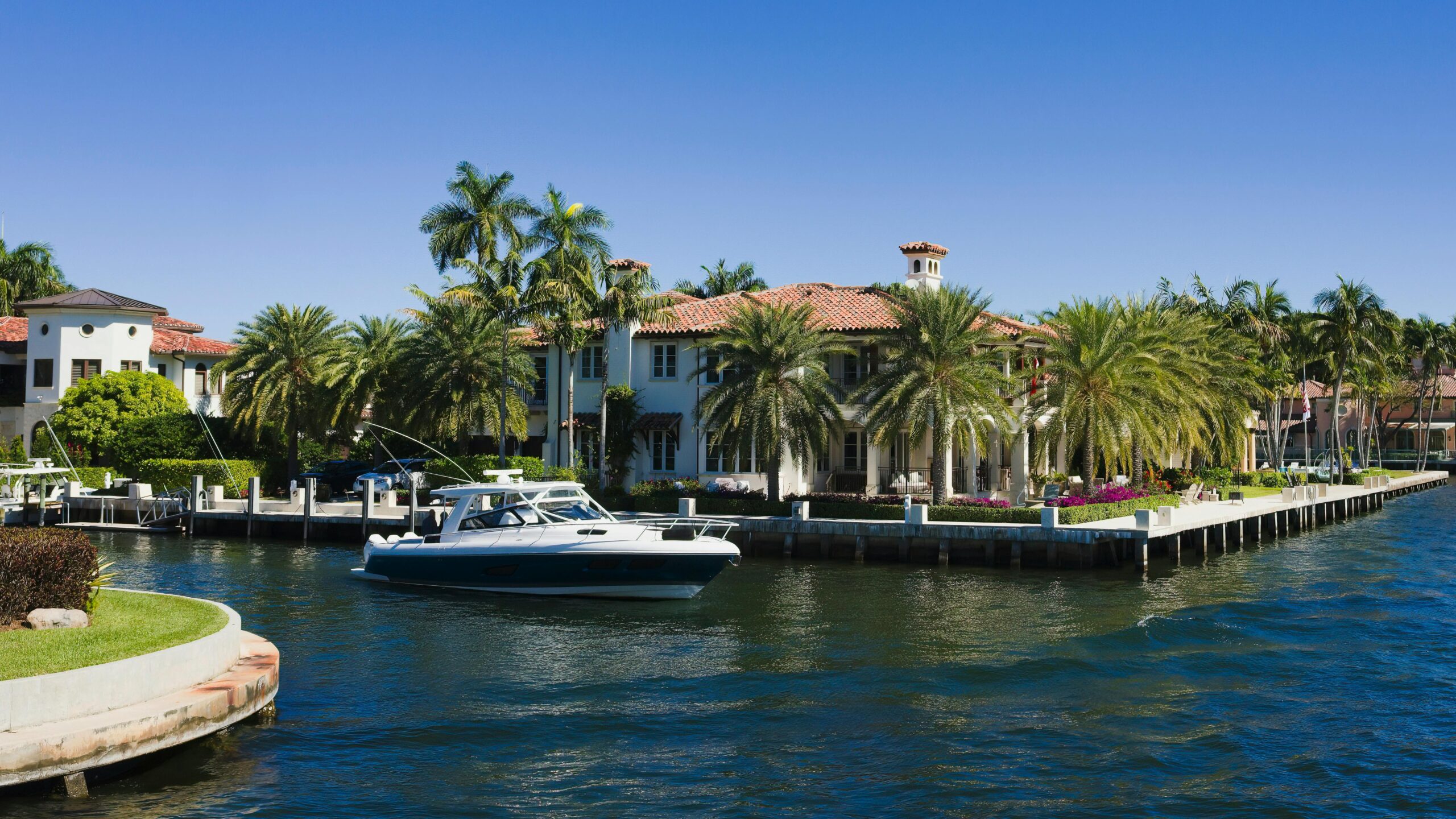 view of boats on a river near the palm trees and mansions