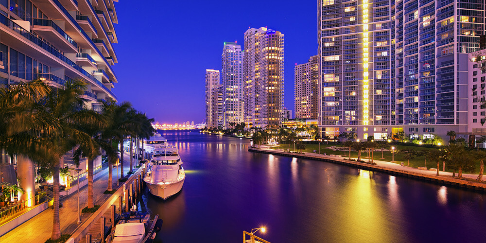 a view of tall buildings near a body of water at night