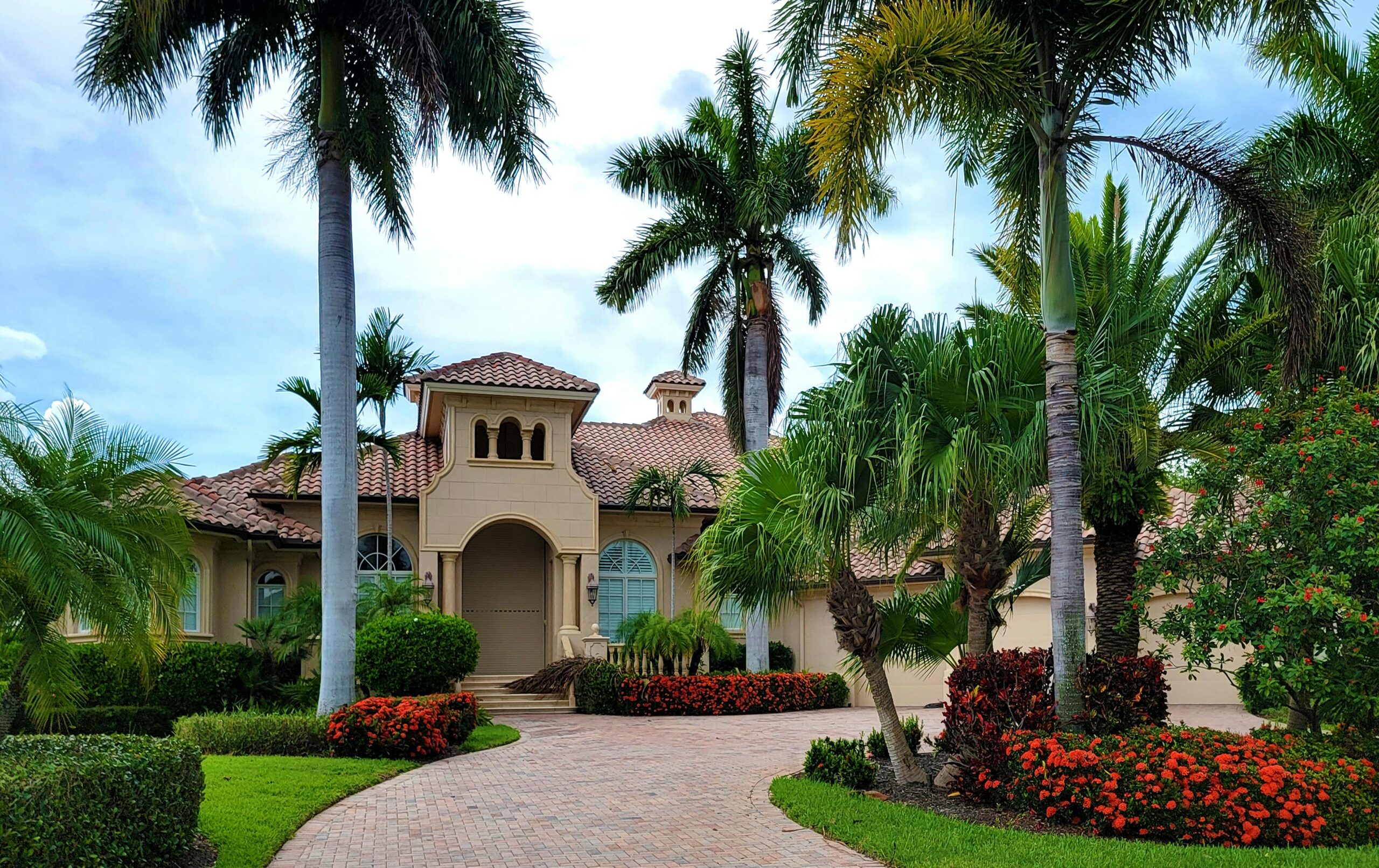 a view of a mansion surrounded by palm trees and plants
