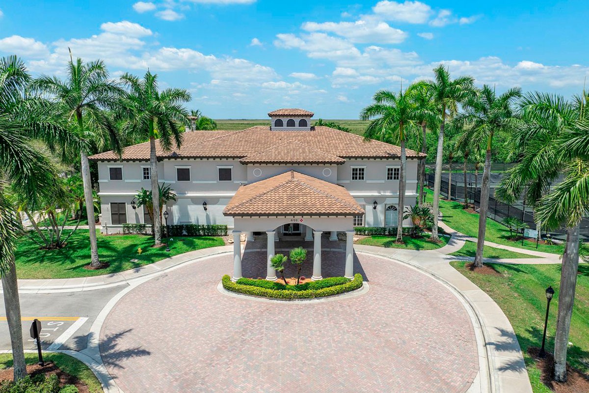 a high view of a club house wth tennis courts on the side